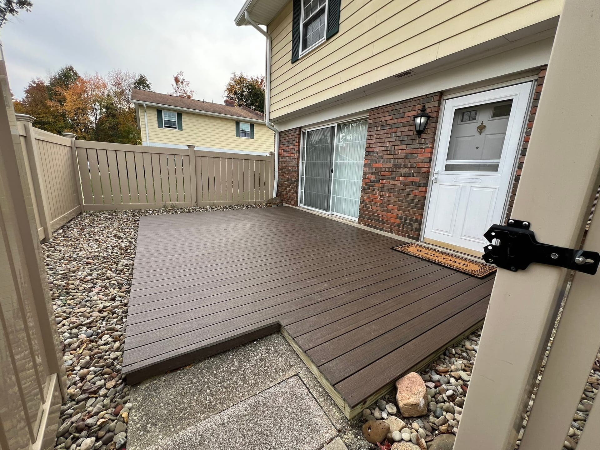 New composite deck with vinyl privacy fence behind a townhome