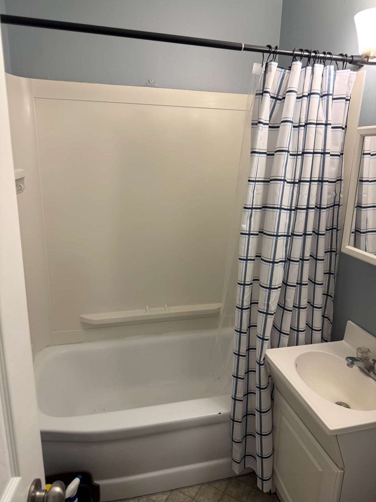Original bathroom with dated tub and shower curtain