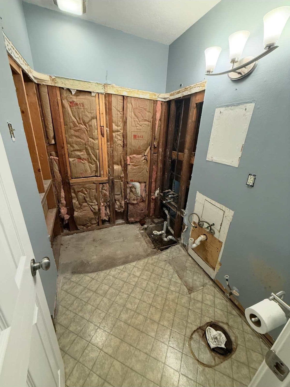 Bathroom opened to the studs with plumbing exposed