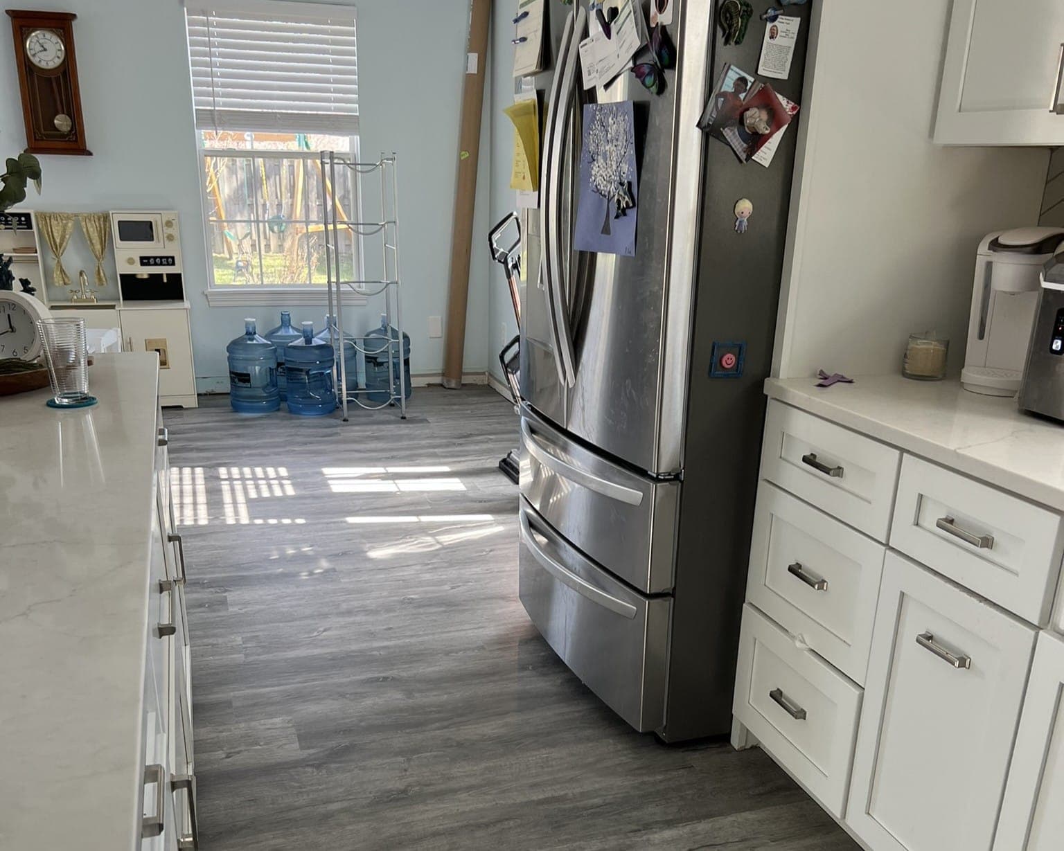 Kitchen with newly installed vinyl plank flooring and stainless appliances